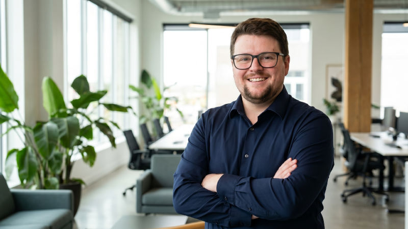 A friendly man posing with his arms crossed in a bright office